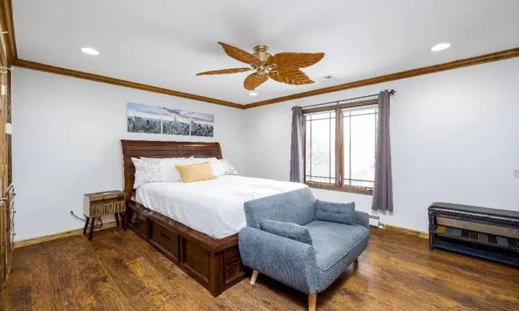 Bedroom with ceiling fan, multiple windows, a baseboard radiator, and hardwood / wood-style flooring