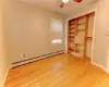 Spare room with hardwood / wood-style floors, a baseboard radiator, and ceiling fan