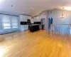 Kitchen featuring a center island, stainless steel fridge, pendant lighting, light hardwood / wood-style floors, and white cabinets