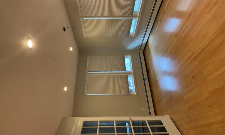 Unfurnished room featuring a baseboard heating unit, a wealth of natural light, and light hardwood / wood-style flooring