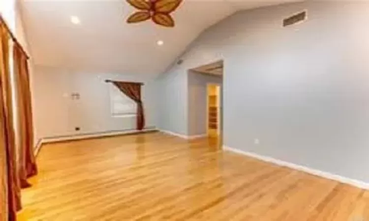 Bonus room with ceiling fan, lofted ceiling, and light wood-type flooring