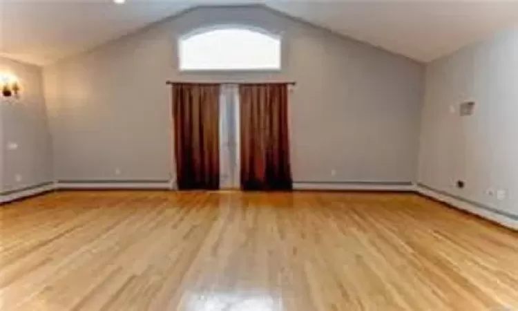 Bonus room with light hardwood / wood-style flooring and lofted ceiling