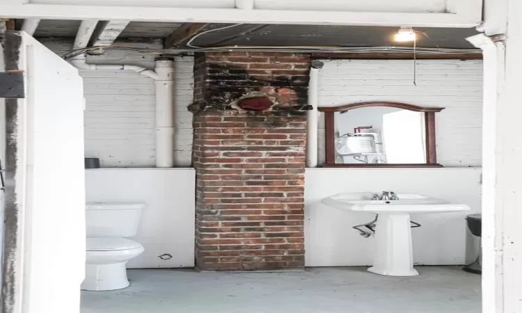 Bathroom featuring concrete flooring and toilet