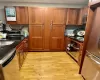 Kitchen with light wood-type flooring Cherry cabinets and granite, sink, appliances with stainless steel finishes, and tasteful backsplash