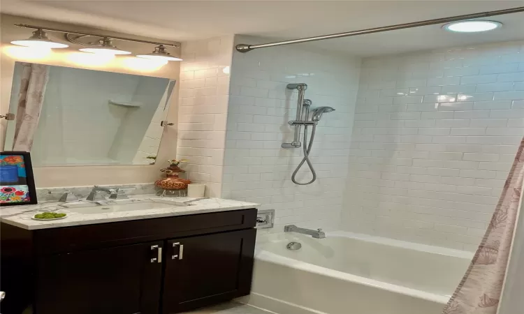 Bathroom featuring vanity and shower / bath combination with curtain