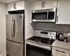 Kitchen featuring stainless steel appliances and white cabinetry