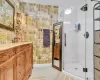 Bathroom featuring tile patterned floors, vanity, and a shower with door