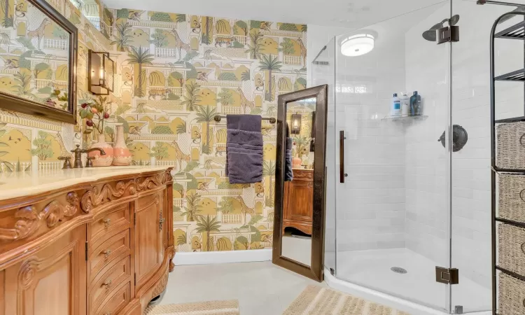 Bathroom featuring tile patterned floors, vanity, and a shower with door