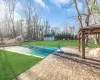 View of pool featuring a lawn, a storage unit, a gazebo, and a patio area