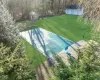 View of swimming pool featuring a shed and a lawn