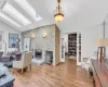 Living room featuring a fireplace, lofted ceiling with skylight, and light hardwood / wood-style flooring