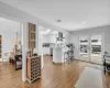 Kitchen featuring kitchen peninsula, island exhaust hood, stainless steel dishwasher, white cabinets, and light hardwood / wood-style floors