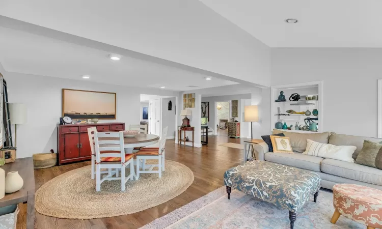 Living room with dark hardwood / wood-style floors and vaulted ceiling