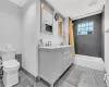 Full bathroom with tiled shower / bath, tile patterned flooring, vanity, and toilet