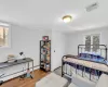 Bedroom featuring hardwood / wood-style floors, crown molding, and a baseboard heating unit