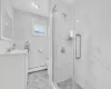 Bathroom featuring toilet, vanity, an enclosed shower, and a baseboard heating unit