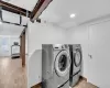 Clothes washing area featuring washer and dryer and light wood-type flooring