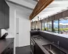 Kitchen featuring dark brown cabinets, sink, lofted ceiling with beams, stovetop, and oven