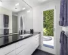 Bathroom featuring tile patterned floors, vanity, and tile walls