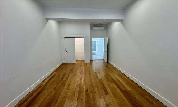 Hall featuring an AC wall unit and light hardwood / wood-style floors