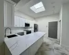 Kitchen featuring white cabinets, sink, light stone counters, kitchen peninsula, and stainless steel appliances