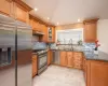 Kitchen featuring dark stone counters, sink, tasteful backsplash, kitchen peninsula, and stainless steel appliances