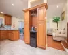 Kitchen with backsplash, dark stone countertops, and beverage cooler