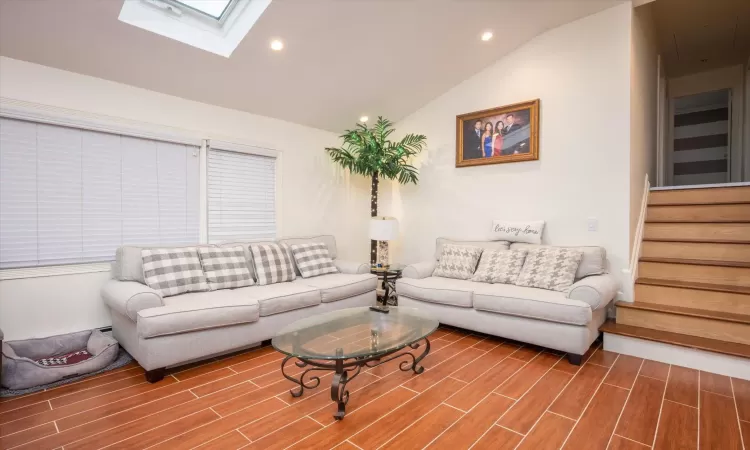 Living room with vaulted ceiling with skylight