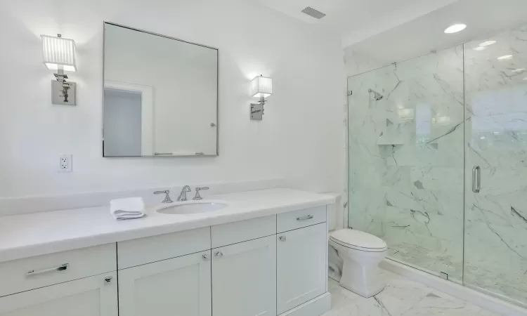 Bathroom with vanity, toilet, and walk in shower