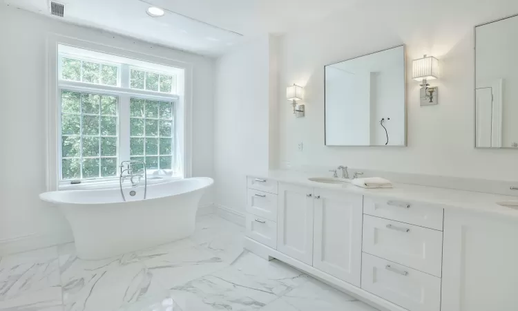 Bathroom featuring double vanity and free standing tub