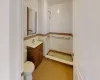 Bathroom featuring vanity, toilet, tile walls, and a tile shower