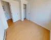 Unfurnished bedroom featuring light wood-type flooring and baseboard heating