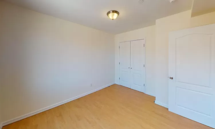 Unfurnished bedroom featuring a closet and light hardwood / wood-style flooring