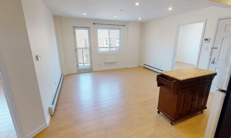 Doorway to outside with baseboard heating and light hardwood / wood-style flooring