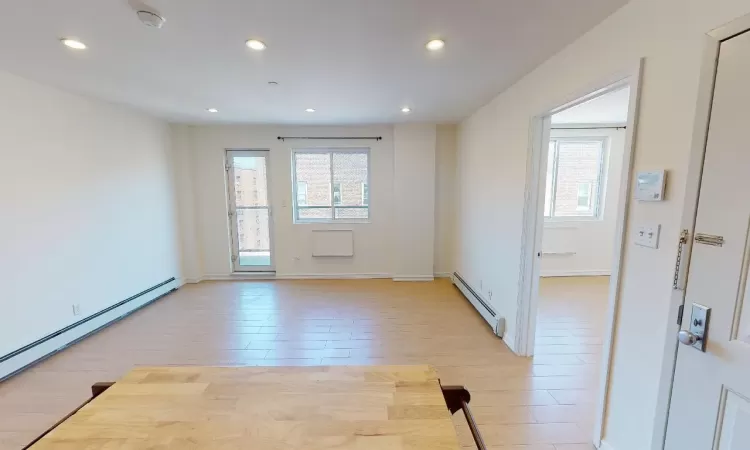 Unfurnished room with light hardwood / wood-style flooring and a baseboard heating unit