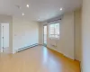 Unfurnished room featuring a baseboard radiator and light hardwood / wood-style flooring