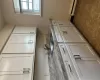 Kitchen with white cabinets, light stone countertops, sink, and a baseboard heating unit