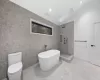 Bathroom featuring plus walk in shower, toilet, tile walls, and lofted ceiling