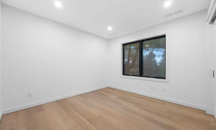 Empty room with light hardwood / wood-style floors