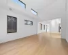 Unfurnished living room featuring light hardwood / wood-style floors and a high ceiling