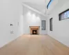 Unfurnished living room with light hardwood / wood-style flooring, a high ceiling, and a brick fireplace