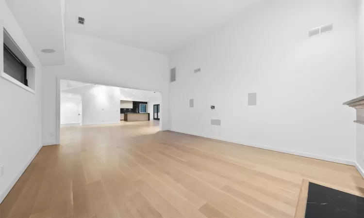 Unfurnished living room with a high ceiling and hardwood / wood-style flooring