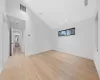 Unfurnished room featuring light wood-type flooring and high vaulted ceiling