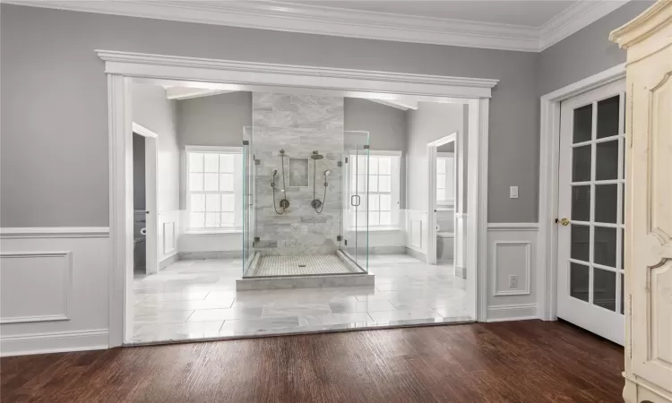 Bathroom with an enclosed shower, toilet, ornamental molding, and wood-type flooring