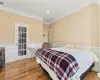 Bedroom featuring light hardwood / wood-style flooring and crown molding