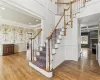 Staircase featuring a fireplace, wood-type flooring, and crown molding