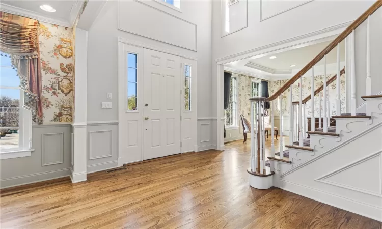 Entrance foyer featuring light hardwood / wood-style flooring and crown molding