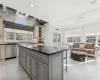 Kitchen with a breakfast bar area, gray cabinets, a kitchen island, and stainless steel dishwasher