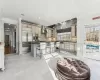 Kitchen with a center island, wall chimney range hood, a kitchen breakfast bar, plenty of natural light, and appliances with stainless steel finishes