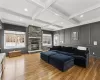 Living room featuring beam ceiling, dark hardwood / wood-style flooring, a fireplace, and coffered ceiling